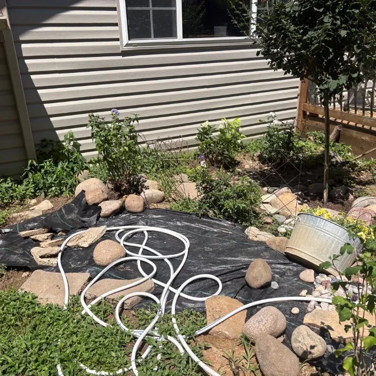 Bed with fabric, loose rock and a hose pile before work, Lake St. Louis