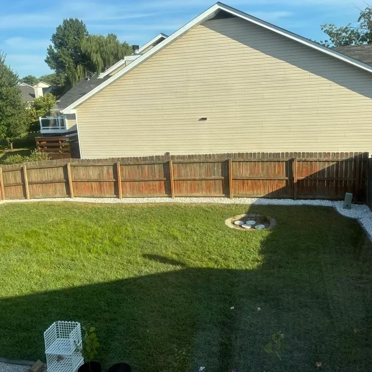 The same corner cleared, the fire pit tidied and a new white-rock border laid along the fence, St. Charles County